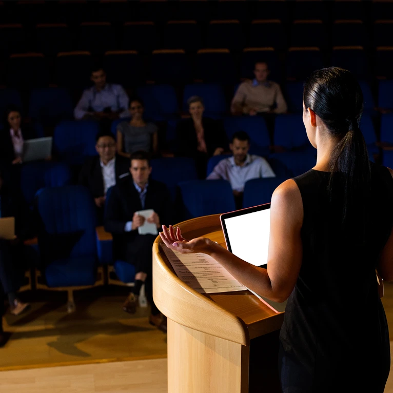 Karina Garza presentando ante un auditorio de directivos